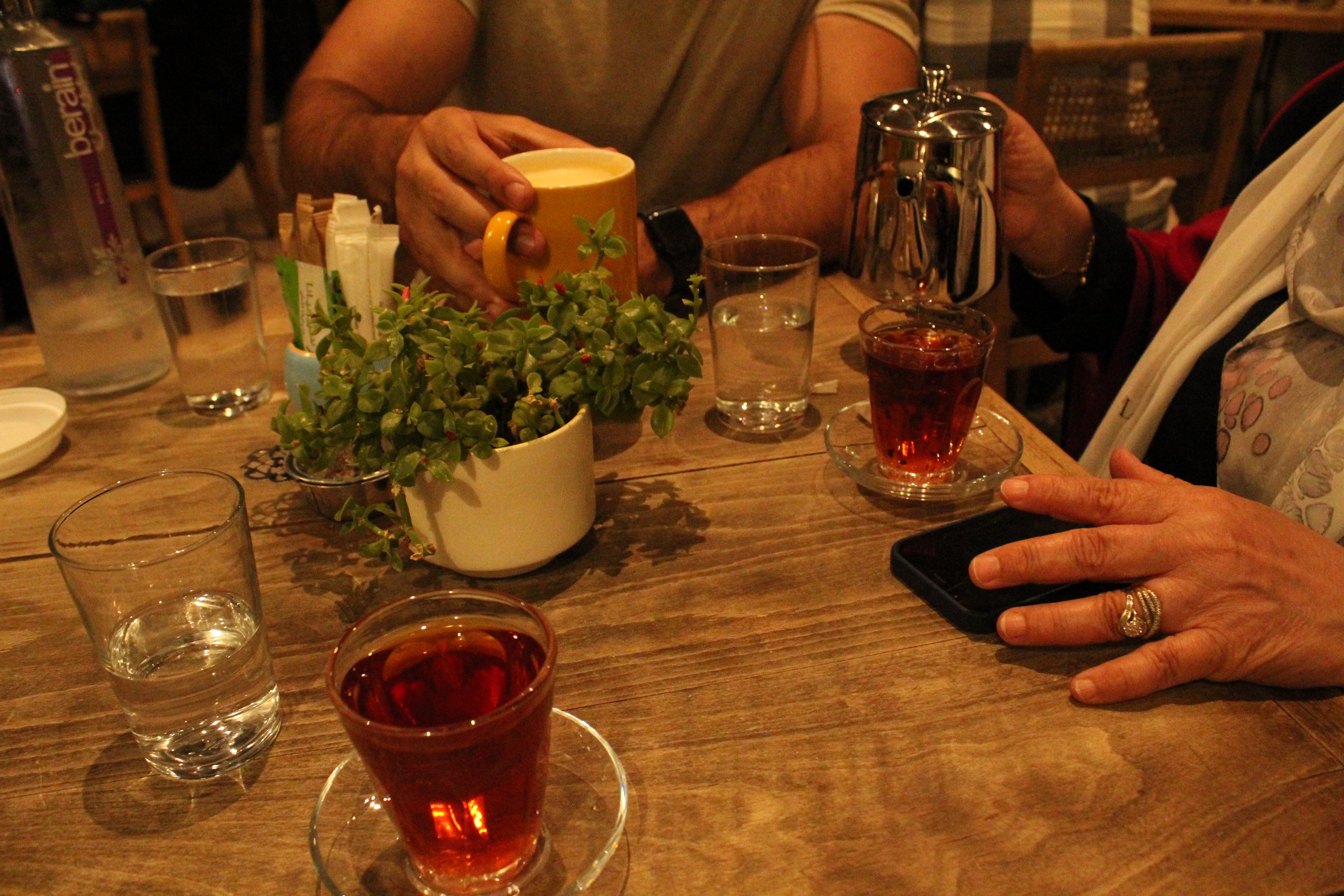 Glasses of Jordanian tea on a wooden café table with fresh herbs