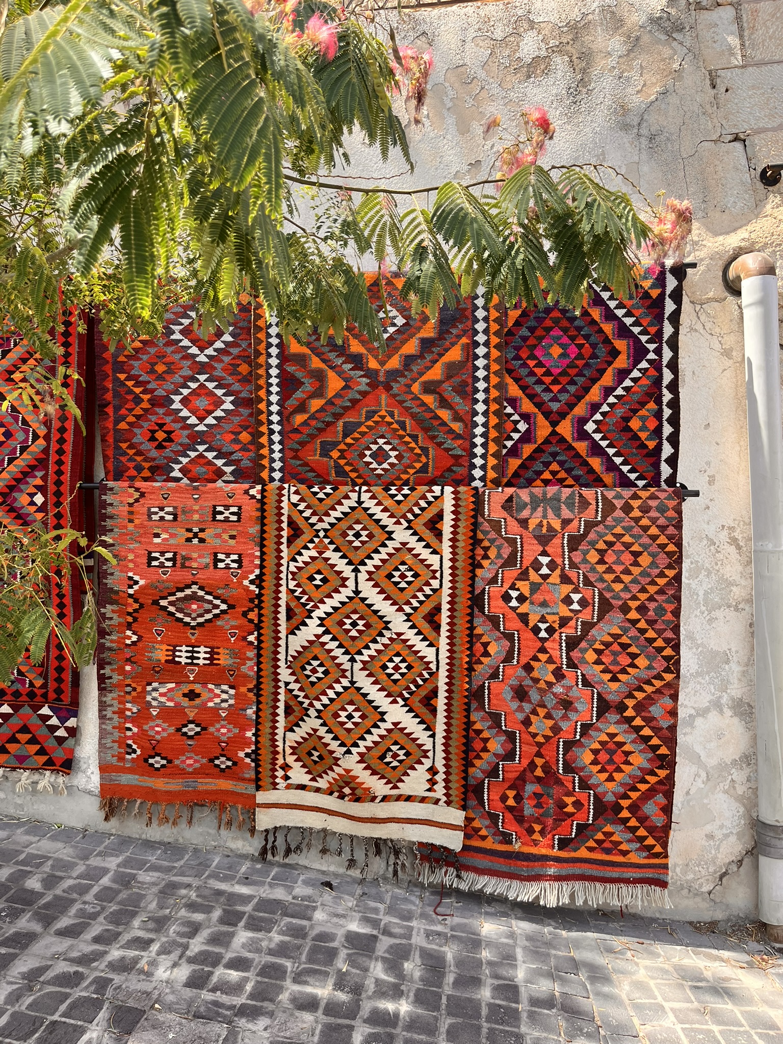 Traditional Jordanian kilim rugs hanging on a wall outside a shop on Rainbow Street Amman
